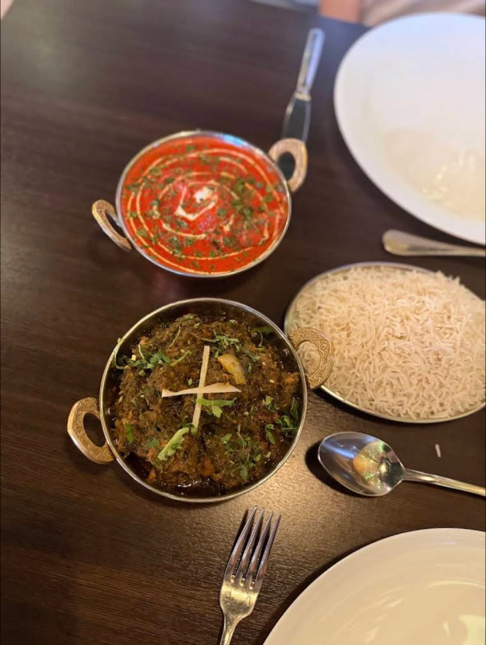 Two traditional Indian curries, a dark Rogan Josh and a bright red Masala, 
served with a side of fluffy white rice at MariGold, Kilmacolm. 